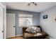 Cozy bedroom featuring a futon sofa, bright window with blinds, and hardwood flooring at 4010 S Rifle Way, Aurora, CO 80013