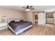 Large bedroom featuring wood flooring, ceiling fan, and a sliding barn door to the bathroom at 4010 S Rifle Way, Aurora, CO 80013
