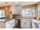 Bright kitchen featuring white cabinets, granite countertops, stainless steel appliances, and natural light at 4010 S Rifle Way, Aurora, CO 80013