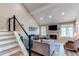 Cozy living room featuring a vaulted ceiling, fireplace, and an open staircase at 4010 S Rifle Way, Aurora, CO 80013