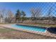 Community pool surrounded by a chain-link fence, trees, and open space on a sunny day at 4010 S Rifle Way, Aurora, CO 80013