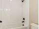 Full bathroom with tub, white tiled walls, and black fixtures, presenting a clean and sleek design for comfort and style at 39417 Stockton Cir, Elizabeth, CO 80107
