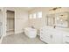 Modern bathroom features a tub, vanity, tile floors, and a walk-in closet at 39417 Stockton Cir, Elizabeth, CO 80107