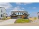 Charming two-story home with a mix of white and gray siding, a well-maintained lawn, and a spacious driveway at 39417 Stockton Cir, Elizabeth, CO 80107