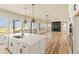 The bright, open kitchen has a large island, quartz countertops, stainless appliances, and an open floor plan at 39417 Stockton Cir, Elizabeth, CO 80107