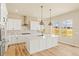 Kitchen features quartz countertops, a large island, stainless appliances, and wood floors at 39417 Stockton Cir, Elizabeth, CO 80107