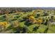 Aerial view of a golf course surrounded by mature trees in vibrant fall colors at 6 Martin Ln, Englewood, CO 80113