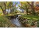 Lush backyard with a flowing creek and mature trees, perfect for relaxation at 6 Martin Ln, Englewood, CO 80113