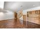 Basement featuring stairs, stained brick floors, built-in cabinets, and natural light at 6 Martin Ln, Englewood, CO 80113