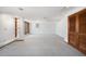 Finished basement area with neutral carpeting, closet space and built-in shelving at 6 Martin Ln, Englewood, CO 80113