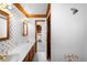 Vintage-style bathroom with floral wallpaper, dual sinks, wood trim, and a separate shower at 6 Martin Ln, Englewood, CO 80113