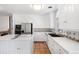 Bright kitchen featuring white cabinets, tile flooring, stainless steel appliances and ample counter space at 6 Martin Ln, Englewood, CO 80113