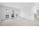 Sunlit living area featuring neutral decor, soft carpeting, and French doors opening to a balcony with a view at 6 Martin Ln, Englewood, CO 80113