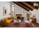 Bright living room featuring vaulted ceilings, wood beams, fireplace, and large windows showcasing natural light at 6 Martin Ln, Englewood, CO 80113