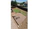 Backyard shot featuring a wood deck, partially completed artificial turf putting green, and wood privacy fence at 12388 Jasmine St, Brighton, CO 80602