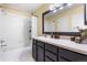 Clean bathroom featuring a shower-tub, a dark vanity, and a large mirror at 12388 Jasmine St, Brighton, CO 80602
