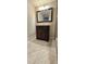 Bathroom featuring a vanity with dark wood-tone cabinetry, tile flooring, and a framed mirror at 12388 Jasmine St, Brighton, CO 80602