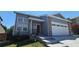 Charming home with gray siding, brick accents, attached garage, and well-maintained front yard at 12388 Jasmine St, Brighton, CO 80602