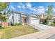 Charming two-story home with blue siding, well-manicured front yard, and two-car garage at 12388 Jasmine St, Brighton, CO 80602