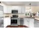 Modern kitchen featuring stainless steel appliances, white cabinetry, and a stylish faucet at 12388 Jasmine St, Brighton, CO 80602
