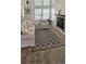 Bright living room featuring a fireplace, carpet floors, neutral-toned furniture, and large windows at 12388 Jasmine St, Brighton, CO 80602