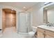 Bathroom featuring a glass shower, toilet, and vanity sink with a view into a wood paneled room at 17979 E Dorado Dr, Centennial, CO 80015