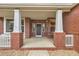 Charming front porch with brick columns and cozy swing, offering a welcoming entrance to the home at 17979 E Dorado Dr, Centennial, CO 80015