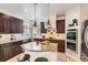 Beautiful kitchen features dark wood cabinets, granite countertops, island with pendant lighting, and stainless steel appliances at 17979 E Dorado Dr, Centennial, CO 80015
