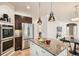 Kitchen with granite island, stainless steel refrigerator, double oven, and dining area visible in background at 17979 E Dorado Dr, Centennial, CO 80015