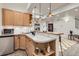 Cozy kitchenette area featuring light wood cabinets, stainless steel appliances, and stylish pendant lighting at 17979 E Dorado Dr, Centennial, CO 80015