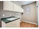 Functional laundry room with ample cabinet space, a utility sink and a window at 17979 E Dorado Dr, Centennial, CO 80015