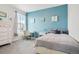 Cozy bedroom featuring a blue accent wall, neutral carpet, and bright window at 965 Peach Leaf Ln, Elizabeth, CO 80107