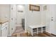 Organized entryway with storage bench, laundry access, and stylish decor elements on durable wood flooring at 965 Peach Leaf Ln, Elizabeth, CO 80107