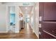 Inviting hallway features wood floors, neutral walls, and charming decor, leading to a bright bedroom at 965 Peach Leaf Ln, Elizabeth, CO 80107
