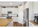 Well-equipped kitchen with modern appliances, white cabinets, granite counters, and stylish hardwood flooring at 965 Peach Leaf Ln, Elizabeth, CO 80107