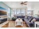 Comfortable living room with blue accent wall, wood floors, large windows, and easy flow to kitchen at 965 Peach Leaf Ln, Elizabeth, CO 80107