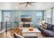 Bright living room featuring blue walls, wood floors, a ceiling fan, and comfortable seating area at 965 Peach Leaf Ln, Elizabeth, CO 80107
