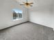 Spacious carpeted bedroom with a ceiling fan and large window overlooking a scenic view at 5521 Spruce Ave, Castle Rock, CO 80104