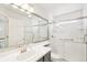 Bright bathroom featuring a glass-enclosed shower with grab bars, sink, and toilet at 5129 Pasadena Way, Broomfield, CO 80023