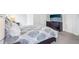 Spacious bedroom featuring patterned bedding, a dresser with a TV, and soft carpeting at 5129 Pasadena Way, Broomfield, CO 80023