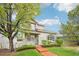 Charming home with a well-manicured lawn, mature trees, and inviting walkway at 5129 Pasadena Way, Broomfield, CO 80023
