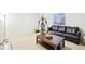 Relaxing living room area with black sofa, coffee table, shelving, and workout equipment at 5129 Pasadena Way, Broomfield, CO 80023