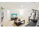 Spacious living room with a TV, shelving, a coffee table, an exercise machine, and a black couch at 5129 Pasadena Way, Broomfield, CO 80023