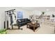 Cozy living room area with an exercise machine, black couch, bookshelves, and coffee table at 5129 Pasadena Way, Broomfield, CO 80023