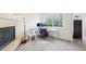 Well-lit office space with a fireplace, dual monitors, and large window, providing a comfortable work environment at 5129 Pasadena Way, Broomfield, CO 80023
