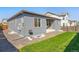 Exterior view of the home's backyard, featuring a grassy lawn and landscaping at 6932 E 133Rd Ave, Thornton, CO 80602
