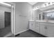 A modern bathroom features dual sinks, neutral paint, generous lighting, and a glass enclosed shower at 6932 E 133Rd Ave, Thornton, CO 80602