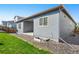 Exterior view of the home showing the side yard, landscaping, and back patio at 6932 E 133Rd Ave, Thornton, CO 80602