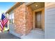 Close-up of a front door with brick siding and an American flag at 6932 E 133Rd Ave, Thornton, CO 80602