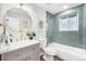 Stylish bathroom with a modern vanity, elegant mirror, and a tub with decorative tile at 8236 W 71St Pl, Arvada, CO 80004